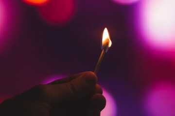 Man holding a lit match on a beautiful background with bokeh