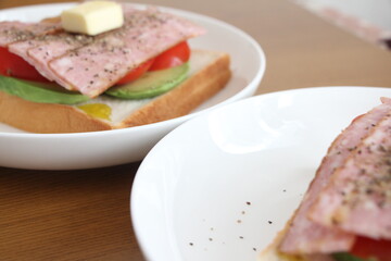パンとバターとトマトとアボカドをのせた白いお皿