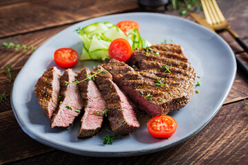 Grilled juicy steak medium rare beef with spices and fresh salad.