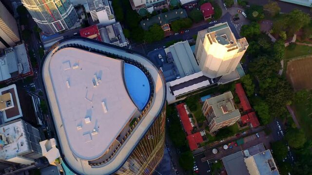 Rooftop Swimming Pool Of Brisbane Skytower At Sunset In Brisbane CBD, Queensland, Australia. - aerial top-down
