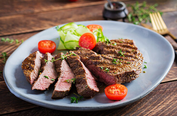 Grilled juicy steak medium rare beef with spices and fresh salad.