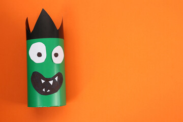 Funny green monster on orange background, top view with space for text. Halloween decoration