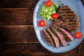 Grilled juicy steak medium rare beef with spices and fresh salad. Top view, overhead, flat lay