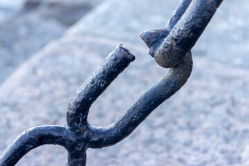 The broken link of an old rusty nautical chain.