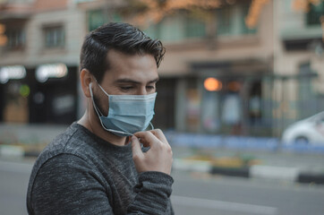 hombre con mascarilla hablando por teléfono en la calle