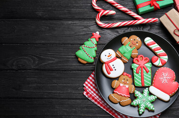 Fototapeta na wymiar Delicious Christmas cookies on black wooden table table, flat lay. Space for text