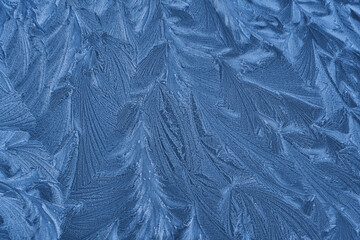 Frost drawing on window glass, snowflake ornament after anomaly ice cold. Blue top view