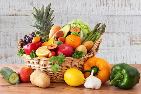 Obst und Gem&uuml;se in einem Korb auf Holz Hintergrund