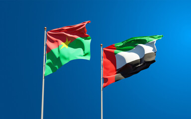 Beautiful national state flags of UAE United Arab Emirates and Burkina Faso together at the sky background. 3D artwork concept.