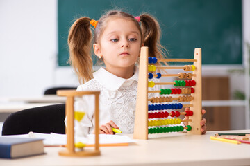 Small girl with abacus in the classroom