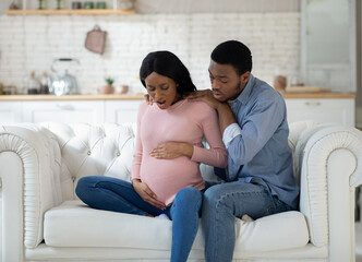 Pregnant black woman feeling pain, giving birth to child, having contractions while husband calling...