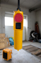 Yellow remote control with a start button in an industrial plant