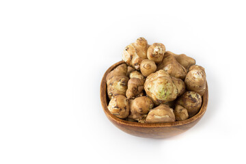 Jerusalem artichoke in a brown wooden bowl on a white background, isolated, close up, superfood, table, top view