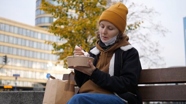 Food To Go, Takeout And Delivery Food Concept During Coronavirus. Woman In Mask Eating Lunch Outside. 