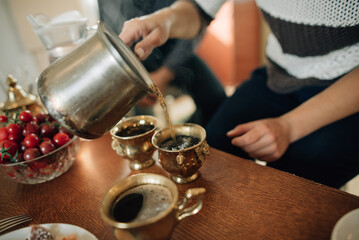 Turkish coffee is poured into golden vintage cups