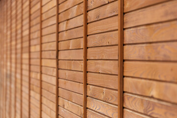 Wooden background, texture - wall of narrow boards selective focus and natural perspective. The texture of the wood horizontal narrow boards are light brown in color. Old shabby wooden background.