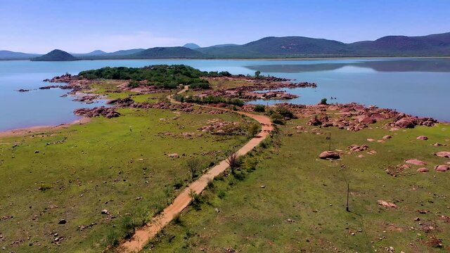 Aerial of a cattle herd drinking water and cooling down at Gaborone dam in Botswana
