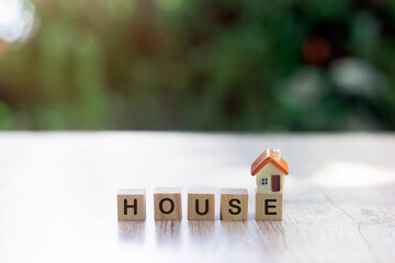 Orange house on a wooden block And the word house on a wooden block Planning ideas for real estate investments, home savings and buying, mortgages and borrowing, banking, accounting and taxes.