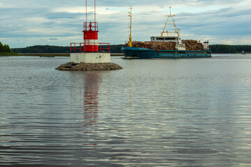 water sign on natural reservoir, sea to indicate danger, cargo ship near the shore against a beautiful sky background