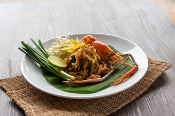 Pad Thai with fresh shrimp on a wooden table Pad Thai is a delicious Thai street food. And popular people around the world