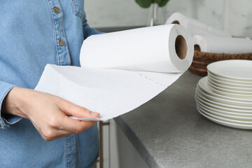 Woman using paper towels in kitchen, closeup
