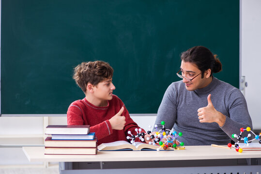 Young male teacher and schoolboy in the classroom