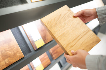 Male hand choosing cabinet panel materials or countertops for built-in furniture design. Shopping...