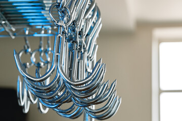 Metal hooks or hangers in a row in proffesional kitchen