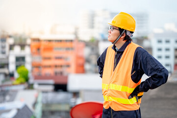 Asian maintenance worker man wearing reflective suit and safety helmet working at construction site. Civil engineering, Architecture builder and building service concepts