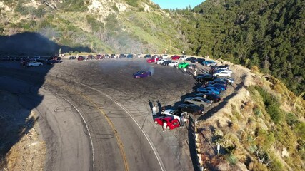 Done shot of muscle and sports cars doing doughnuts and burnouts with a car club in the Angeles National Forest in Southern California