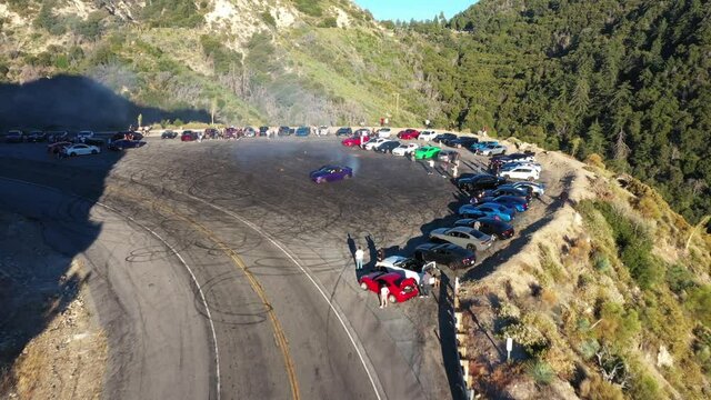Done shot of muscle and sports cars doing doughnuts and burnouts with a car club in the Angeles National Forest in Southern California