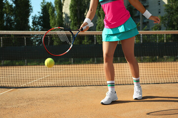 Fototapeta na wymiar Sportswoman playing tennis at court on sunny day, closeup