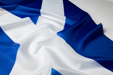 Rippled flag of Scotland lying on white surface
