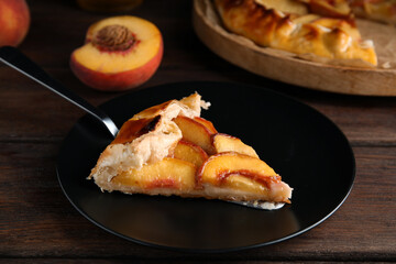Piece of delicious fresh peach pie served on wooden table