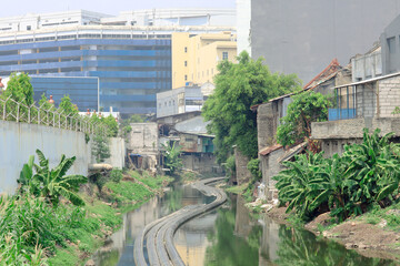 a pipe that floats on the river with the edge of a shabby resident's house and the blue back of the building