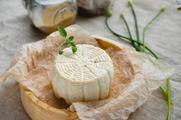 White cheese on a wooden board with olive oil on a brown background.