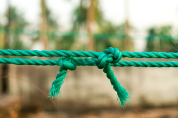 Rope tie knot Closeup. Rope with a two tied knot in the middle isolated from background. A symbol of trust, strength, safety support faith and togetherness concept. Illustrative conceptual photography