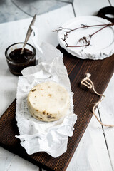 Milk products. Caciotta Al Tartufo cheese on a white wooden background. From homemade fresh milk.