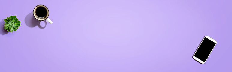 Smartphone with a coffee mug and succulent plant - flat lay