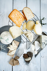 Various types of cheese. On a white wooden background. Blue cheeses with spices. Around honey and walnuts. Home cheese dairy