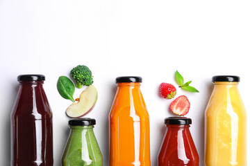 Flat lay composition with bottles of colorful juices and fresh ingredients on white background