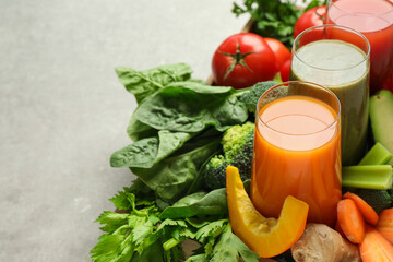 Delicious vegetable juices and fresh ingredients on light grey table