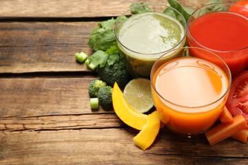 Delicious vegetable juices and fresh ingredients on wooden table. Space for text