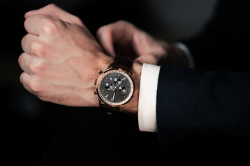 Hand with wrist watch in a business suit close up