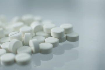 White pills on glass table