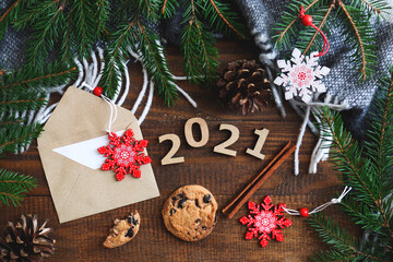 Festive flat lay with cookies, envelope, wooden numbers 2021, Christmas toys and Christmas tree branches. New Year and Christmas concept. Cozy winter postcard. Top view