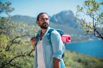Obraz premium Male tourist in a mountain grove overlooking the sea