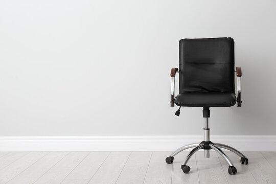 Comfortable Office Chair Near Light Wall Indoors. Space For Text