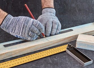 Woodwork and furniture making concept. Carpenter in the workshop makes markings of wooden workpieces