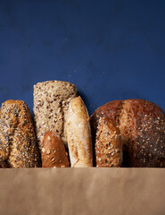 Bread bakery background. Assortment of baked bread brown and white wheat grain loaves in crafting...